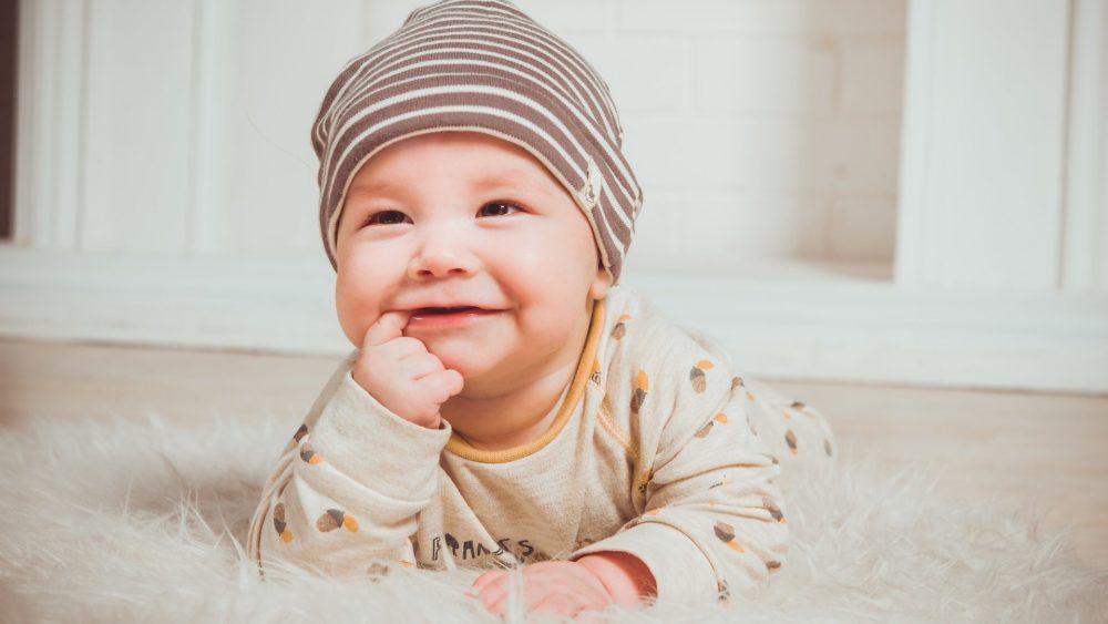 腹ばいで笑顔の赤ちゃんの写真