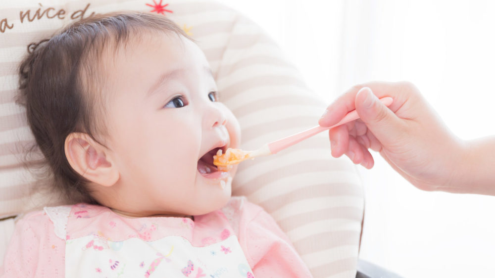 離乳食を食べる女の赤ちゃんの写真