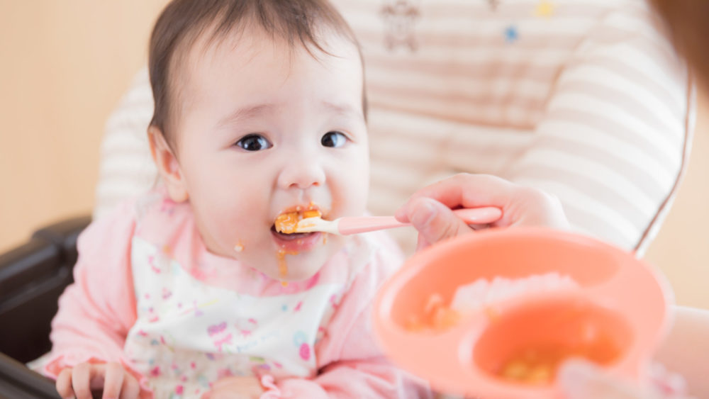 離乳食を食べようとしている赤ちゃんの写真