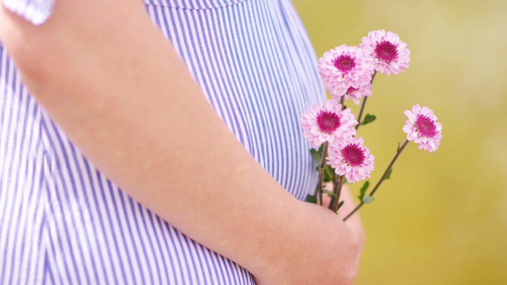 妊娠中の女性のピンクの花の写真