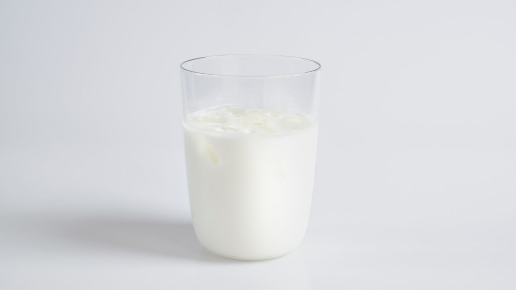 透明なコップにミルクが入った写真