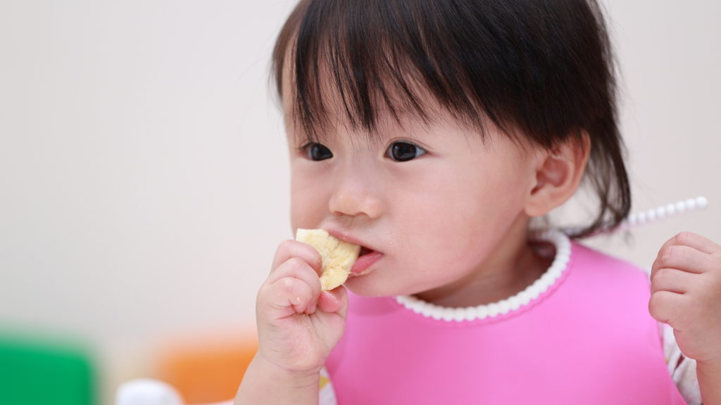 離乳食のつかみ食べをしている赤ちゃんの写真